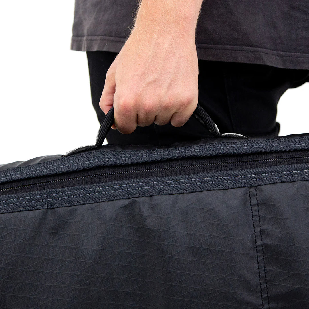 a person pulling a black piece of luggage