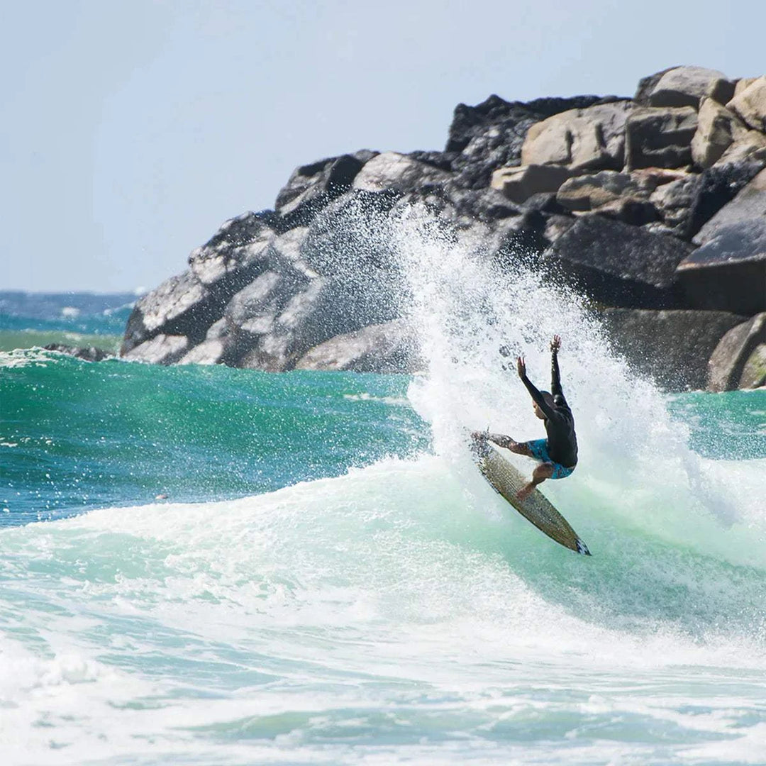 a man riding a wave on top of a surfboard