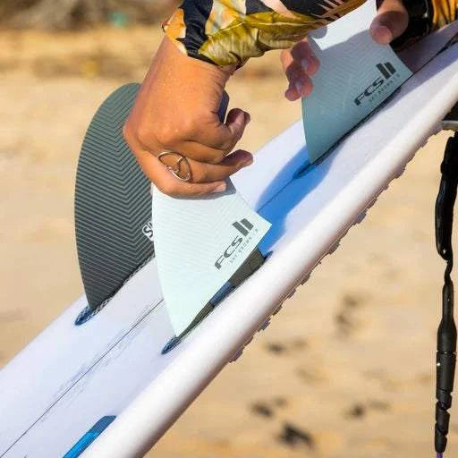 a person is holding a surfboard on the beach