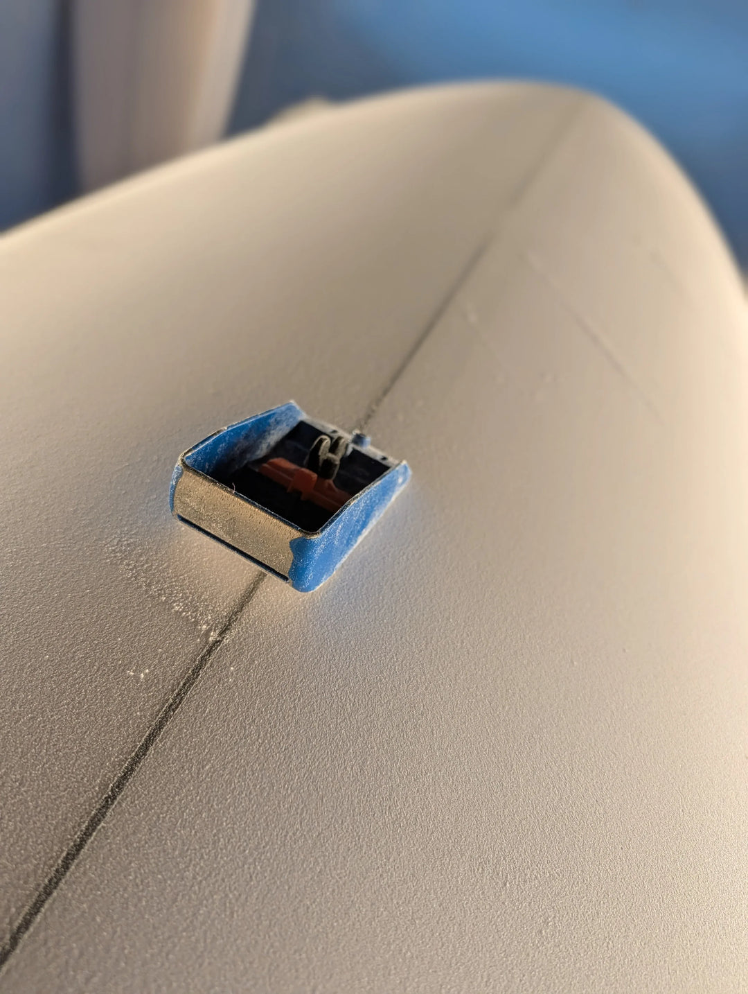 planer on surfboard being shaped